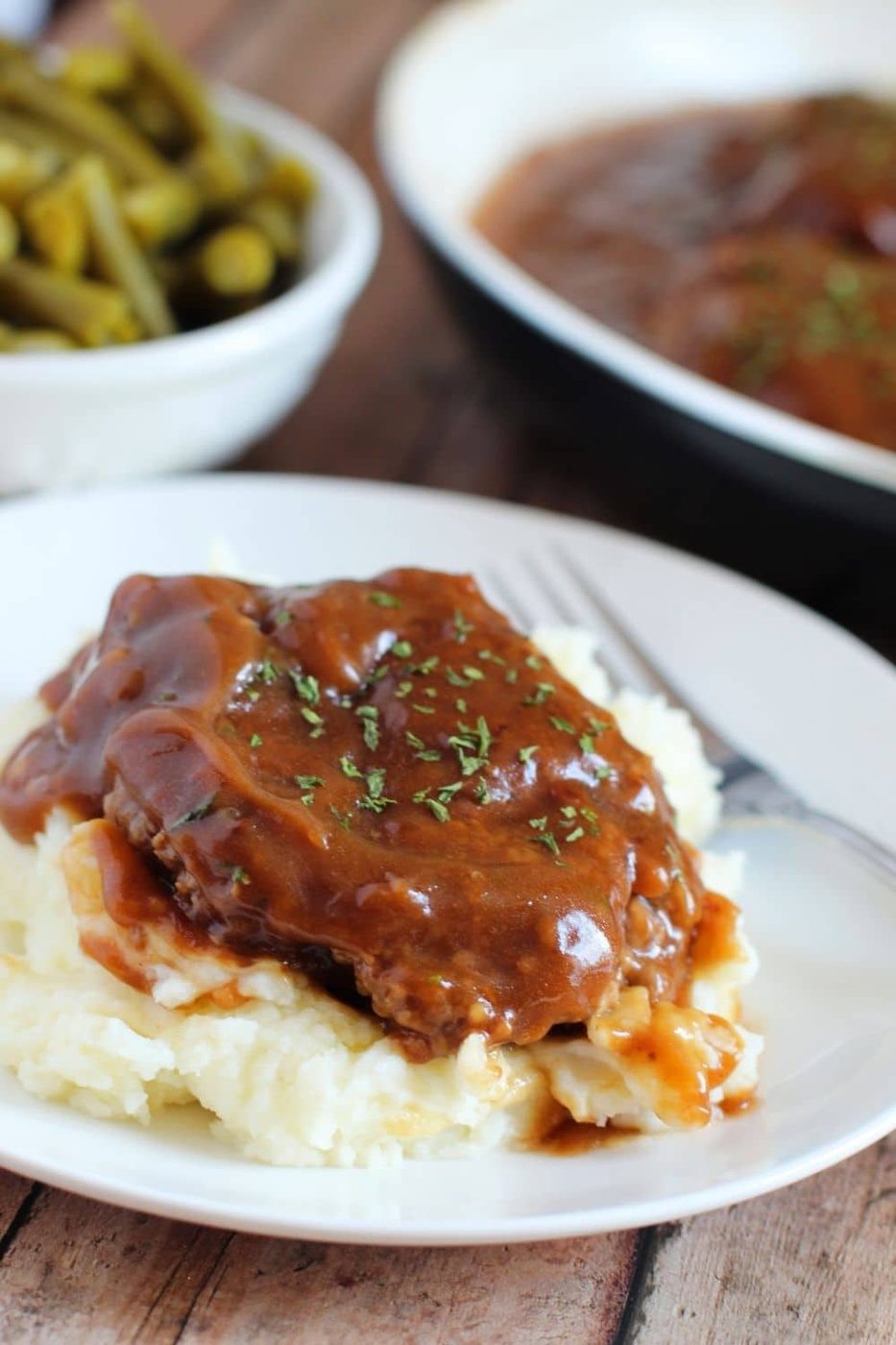 mashed potatoes topped with salisbury steak 
