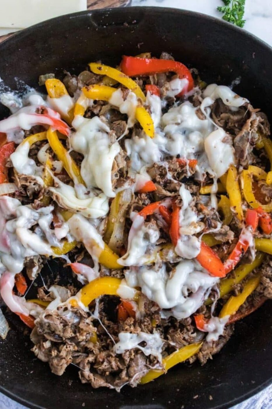 Skillet Shaved Steak on a Bun and cheese mixture in a cast iron skillet