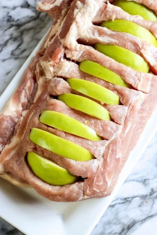 pork loin with apples stuck in it