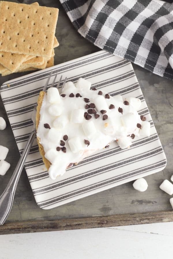 chocolate pudding pie on plate with graham cracker by it