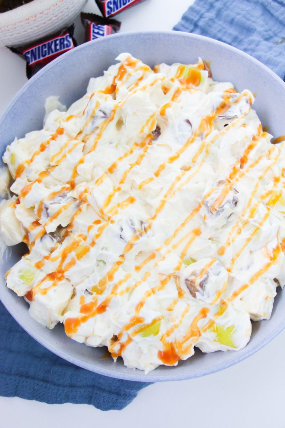 apple salad in a bowl with caramel sauce drizzled on top