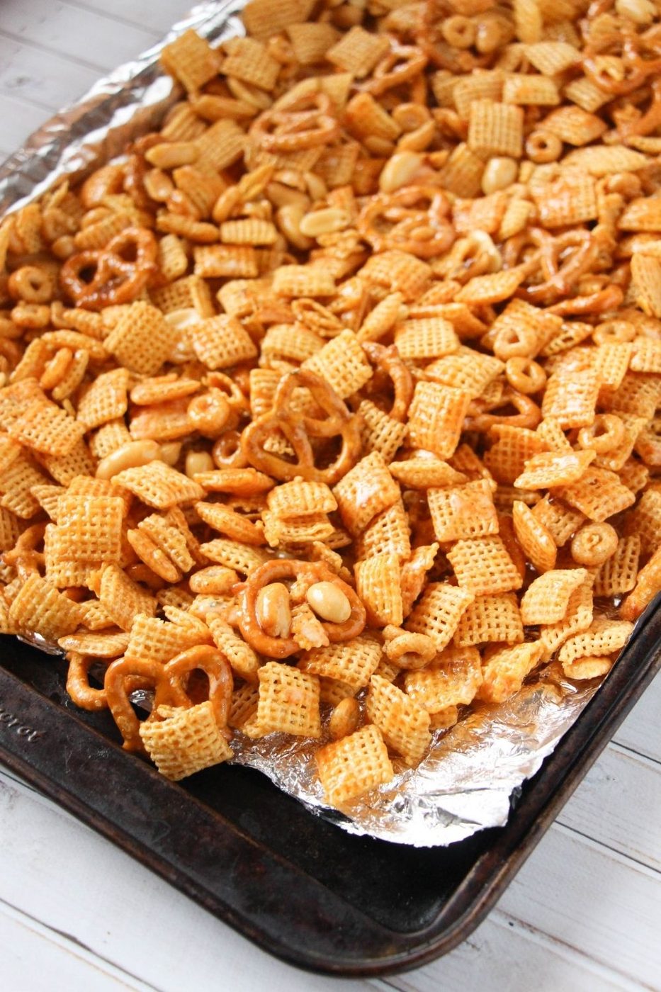 spicy snack mix on the baking sheet with aluminum foil