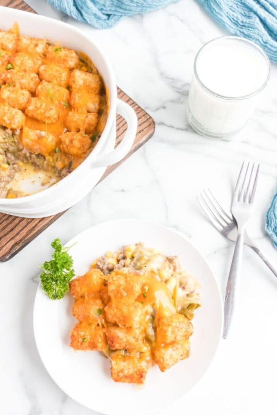 Tater Tot Casserole on a plate and the rest of the pan on table behind the plate 