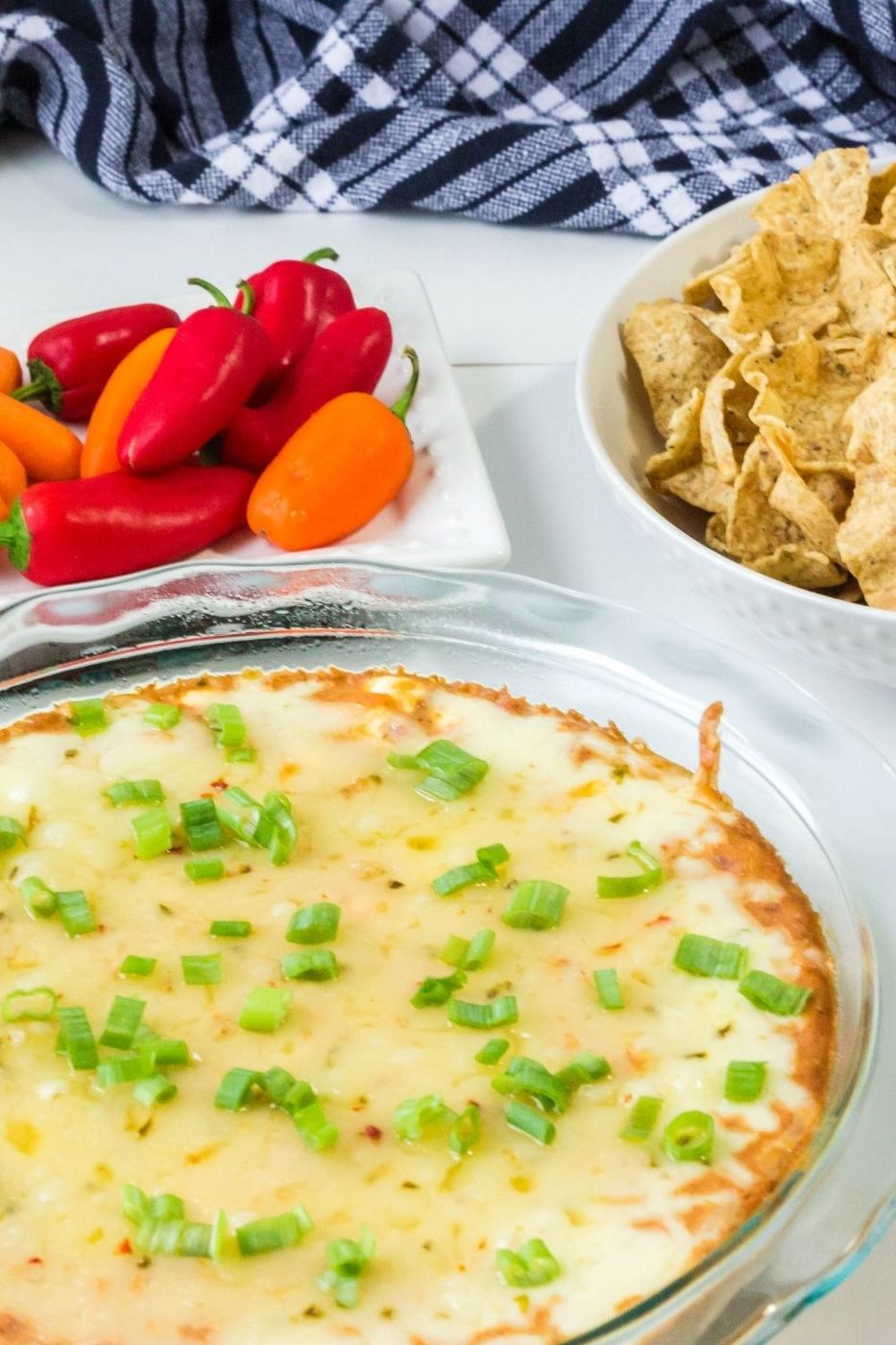 bean dip and chips and veggies on platters on white counter