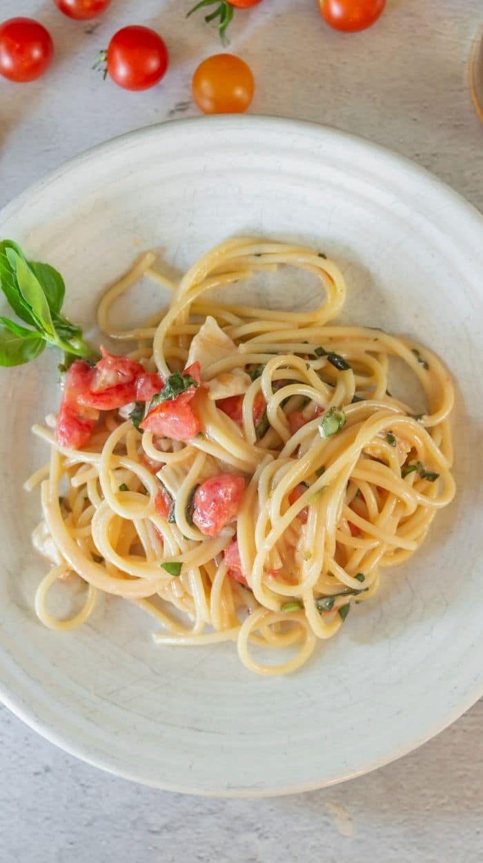 pasta on a white plate with little tomatoes