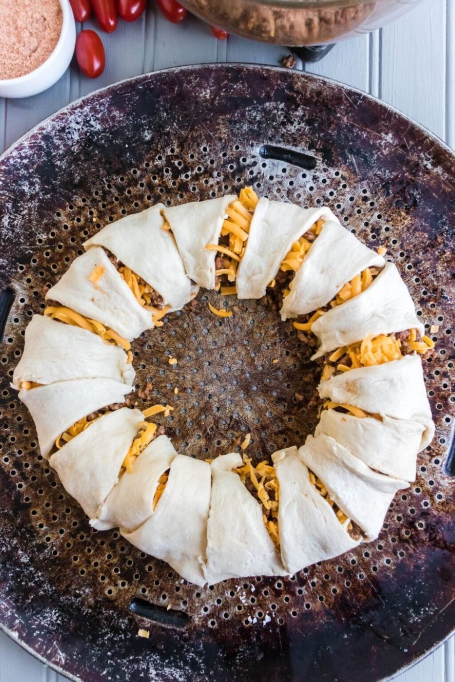 Taco Ring wrapped with crescent rolls on a baking sheet in raw form 