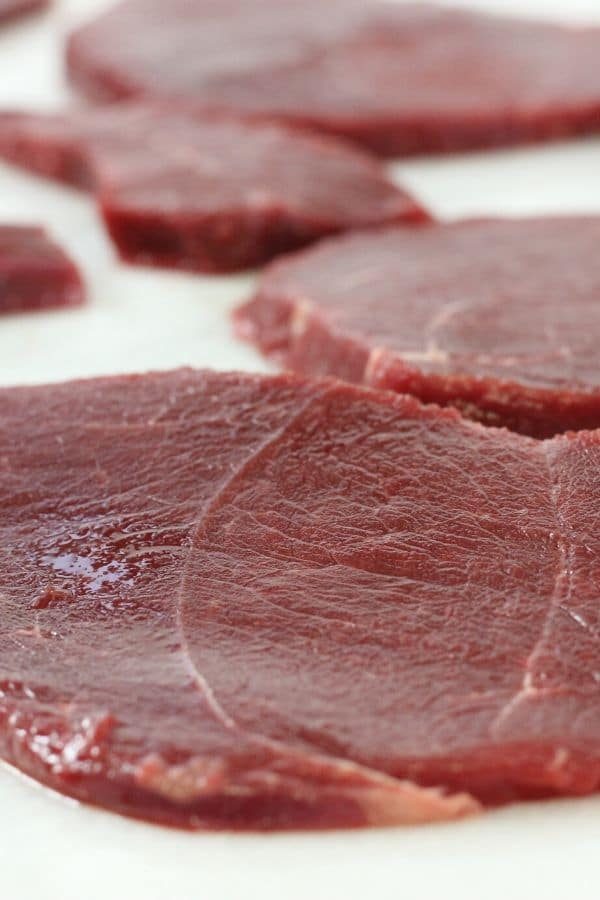 close up of deer meat sliced on cutting board