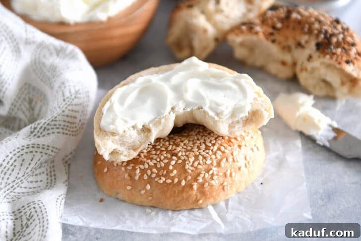 The Ultimate Homemade Bagel Recipe 3 One half of homemade bagel slathered with cream cheese on top of sesame seed top half.