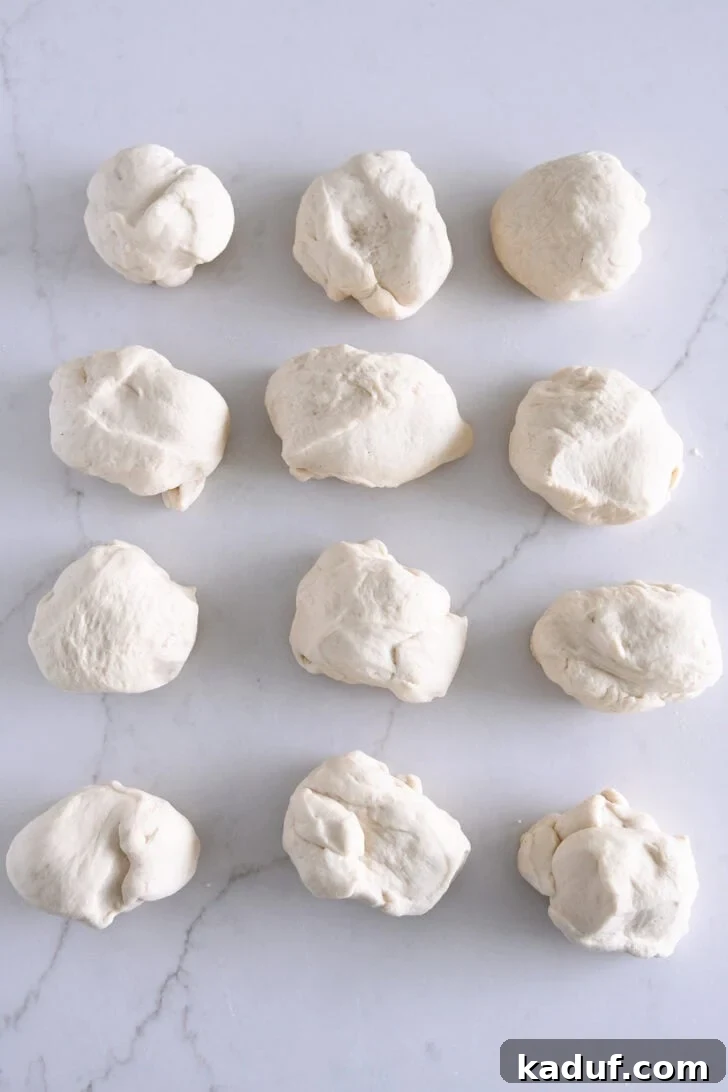 The Ultimate Homemade Bagel Recipe 4 Dough split into 12 pieces on white counter.