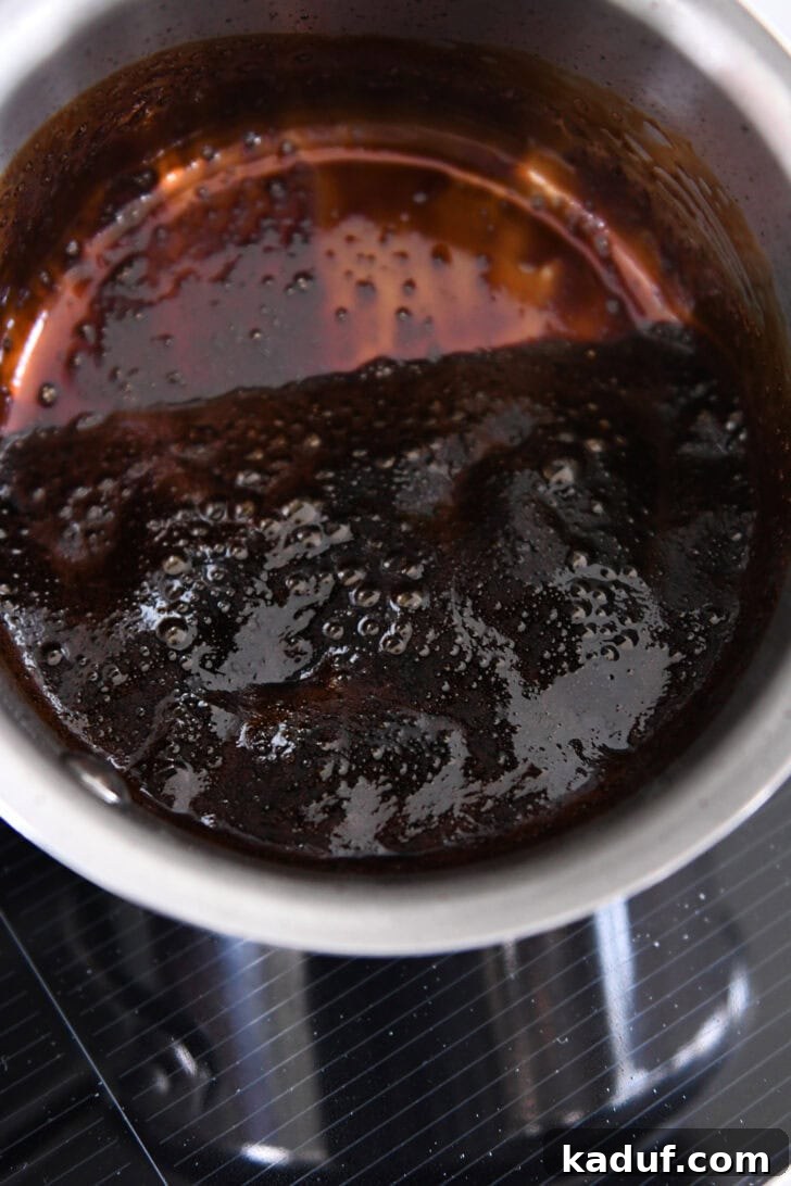 Thick, syrupy reduced balsamic vinegar in a small stainless pot, ready to elevate your pasta dish.