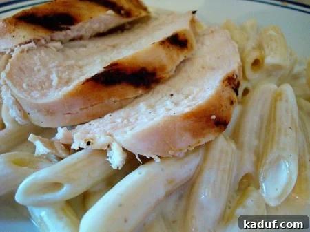 Creamy Gorgonzola Chicken Penne 2 Grilled chicken and penne pasta bathed in a rich, creamy gorgonzola sauce, garnished on a plate.