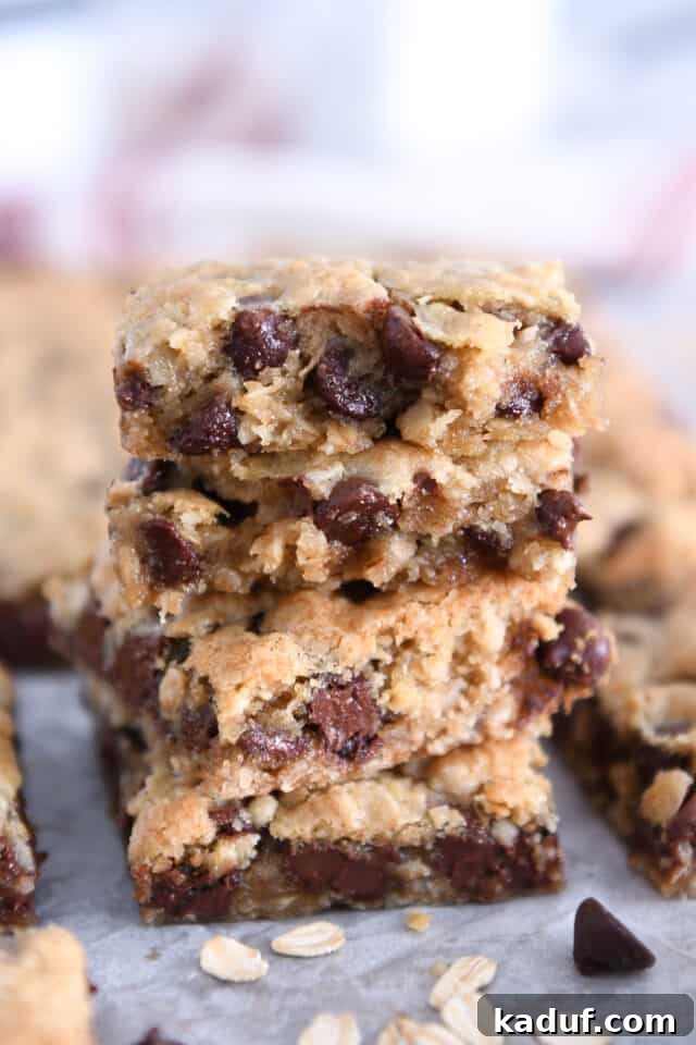 Golden Oat Chocolate Chip Squares 9 Several stacked oatmeal chocolate chip cookie bars, showcasing their golden-brown edges and soft centers.