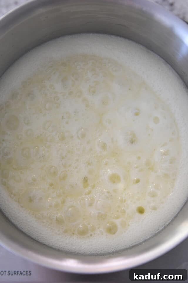 Sweet Tangy Buttermilk Caramel 4 Cream colored syrup bubbling in saucepan.