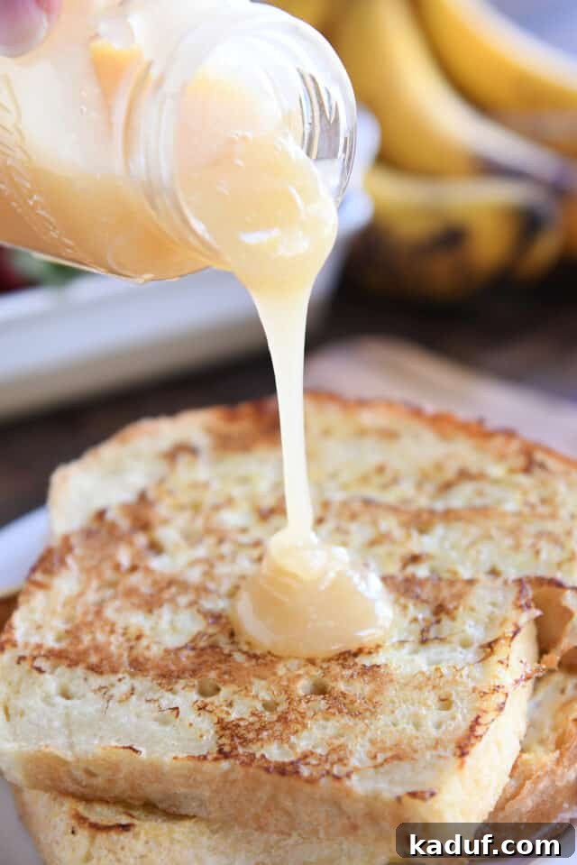 Sweet Tangy Buttermilk Caramel 8 Pouring cream colored syrup over two pieces of French toast on white plate.