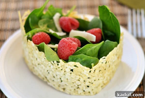 Crispy Asiago, Sweet Raspberry & Fresh Spinach Salad 2 A vibrant spinach and raspberry salad, beautifully presented within a ring of golden, crisped Asiago cheese, garnished with shaved Parmesan.