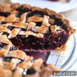 Berry Trio Bliss 10 Triple berry pie in glass pie dish with one piece removed.