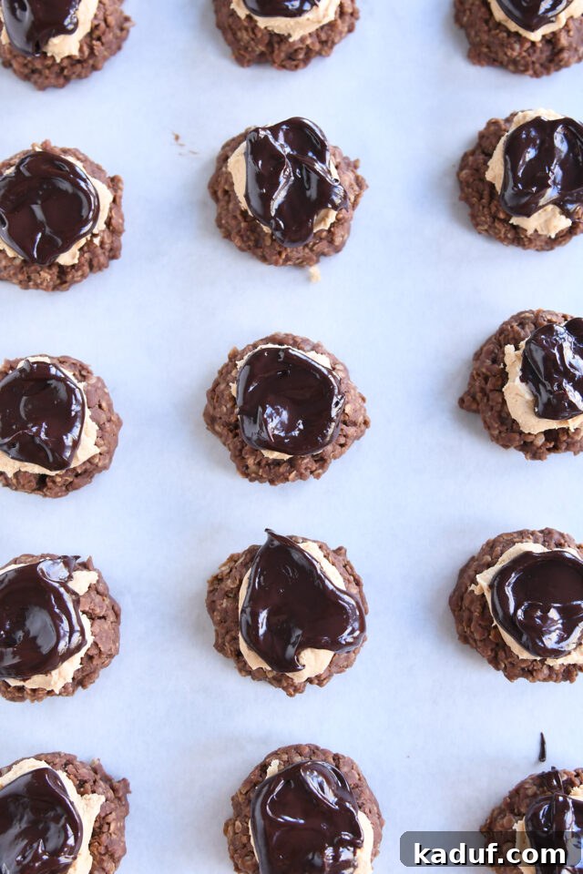 Many finished no-bake chocolate peanut butter buckeye cookies on white parchment paper.
