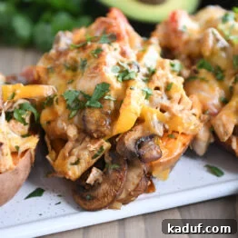 Several sweet potatoes on white tray with mushrooms, bell peppers, and cheese.
