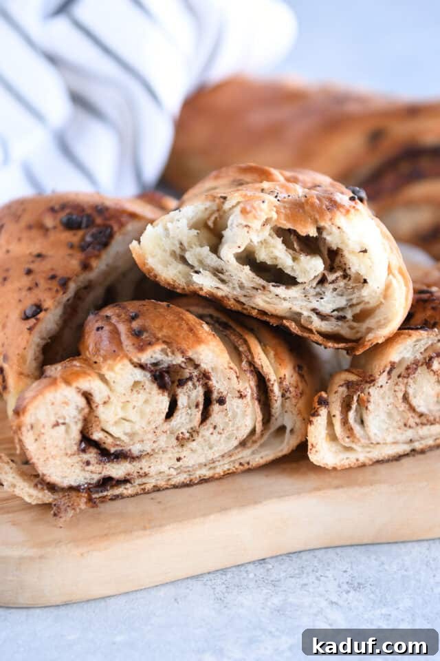 French Chocolate Swirl Bread 2 Three halves of chocolate croissant French bread, showcasing flaky layers and melted chocolate.