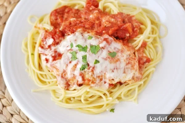 Golden Skillet Chicken Parmesan 3 Top view of chicken parmesan over a bed of noodles on a white plate, ready to be served.