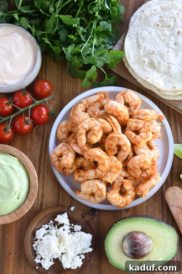 Zesty Chile Lime Shrimp Tacos 6 Plate of shrimp, cherry tomatoes, avocado sauce, tortillas, cilantro, and cotija cheese.