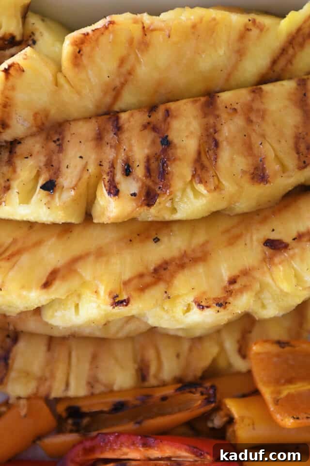 Tropical Chicken Teriyaki Power Bowl 5 A stunning close-up of perfectly grilled pineapple slices, featuring beautiful char marks and a glistening, caramelized surface, highlighting their enhanced sweetness and juicy texture.