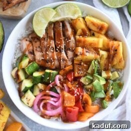 A white bowl showcasing grilled chicken, avocados, fresh lime wedges, pineapple, and peppers, arranged attractively alongside limes and pickled onions.