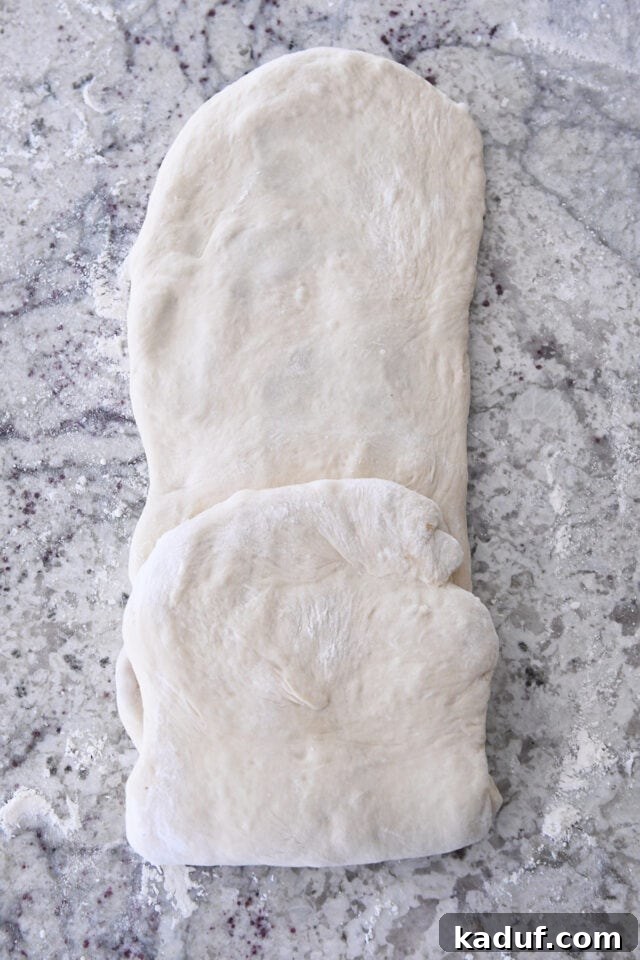 Flaky Cinnamon Croissant Swirl 11 One short end of the long dough rectangle folded precisely to the middle, initiating the second series of folds.