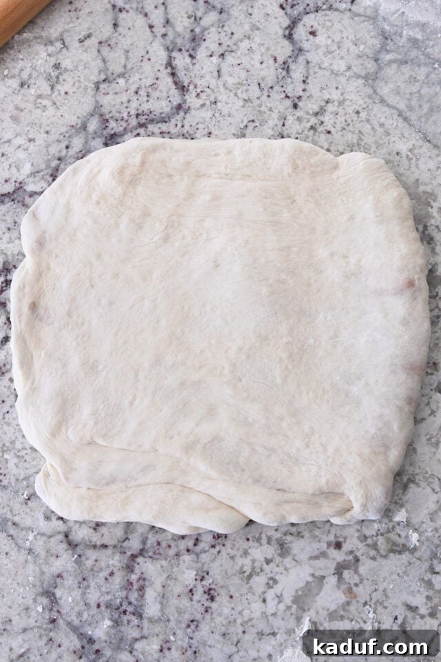 Flaky Cinnamon Croissant Swirl 15 The dough successfully pressed into a uniform square, ready for cutting into strips.