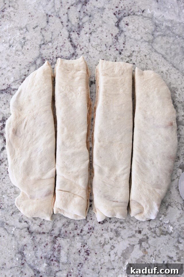 Flaky Cinnamon Croissant Swirl 16 A square of dough meticulously cut into four even strips, showcasing the ready-to-twist portions for croissant bread with cinnamon sugar filling.