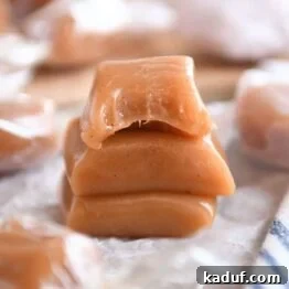 Three apple cider caramels stacked on parchment, showcasing their inviting texture.
