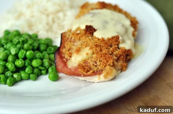 Gourmet Chicken Cordon Bleu Made Simple 6 A beautifully plated chicken cordon bleu portion, drizzled with white sauce, served with green peas and roasted potatoes.