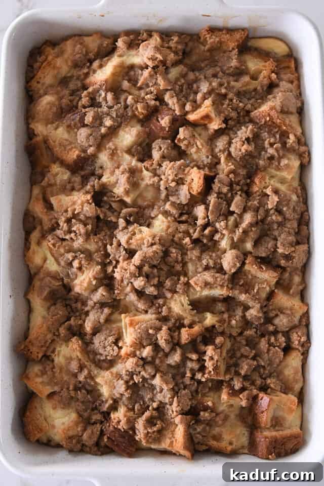 White pan with baked bread cubes for French toast bake and cinnamon streusel.