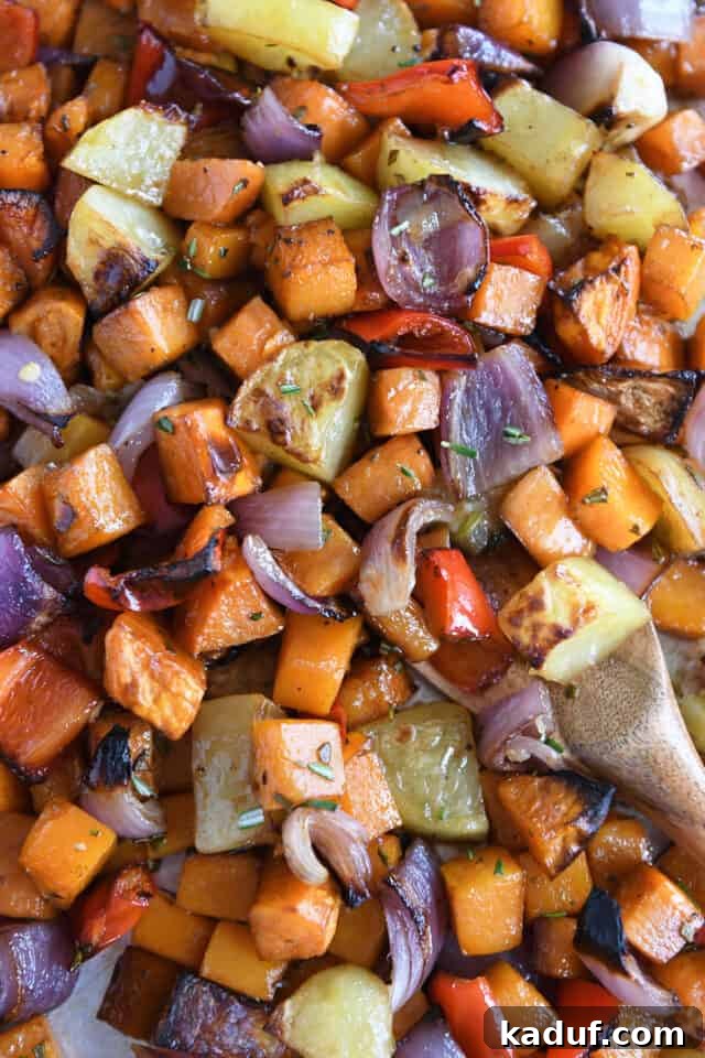 Hearty Balsamic Glazed Root Vegetables 2 Vibrant roasted potatoes, red onions, red bell peppers, and butternut squash, perfectly caramelized on a sheet pan, ready to serve.