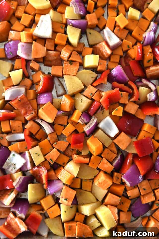 Hearty Balsamic Glazed Root Vegetables 5 Sheet pan with uncooked winter vegetables drizzled with balsamic vinaigrette, ready for the oven.
