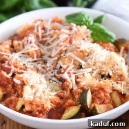One-Pan Italian Cheesy Chicken and Zucchini 11 Serving of chicken zucchini Italian skillet in white bowl with parmesan cheese and fresh basil.