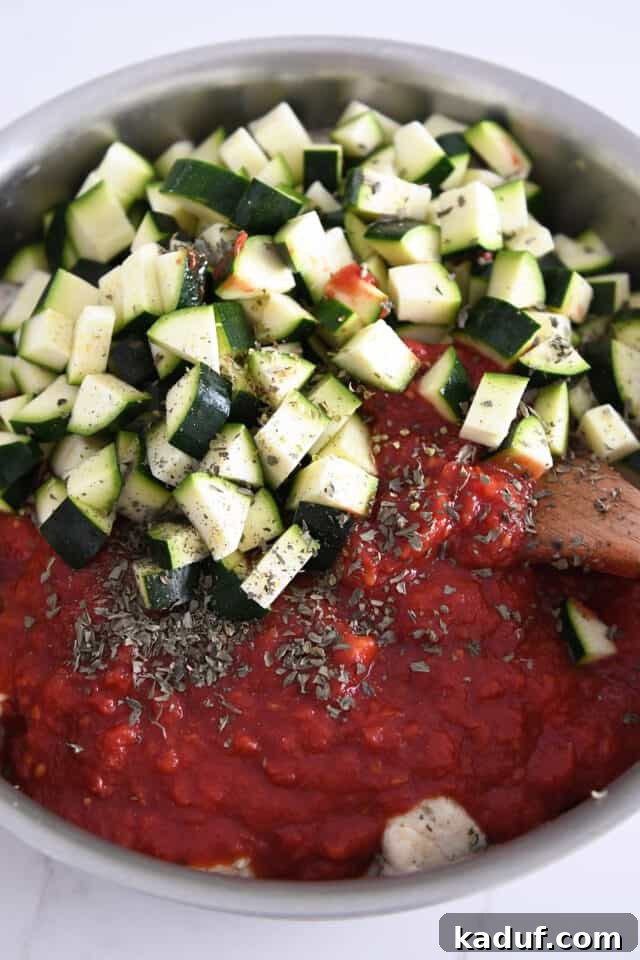 One-Pan Italian Cheesy Chicken and Zucchini 4 Skillet with crushed tomatoes, chicken, herbs and zucchini.