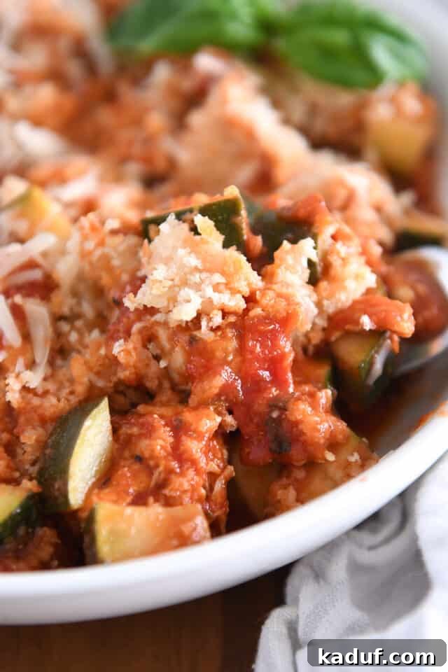 One-Pan Italian Cheesy Chicken and Zucchini 10 Zucchini, panko bread crumbs, tomato sauce and chicken in white bowl.