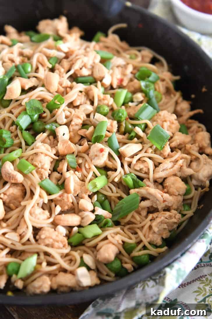 Effortless Fiery Garlic Ramen 2 Ramen noodles with peas, green onions, ground turkey and cashews in cast iron skillet.