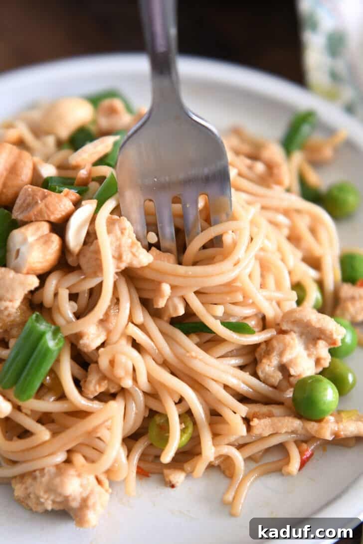 Effortless Fiery Garlic Ramen 10 Fork twirling bite of ramen noodles with peas and green onions.