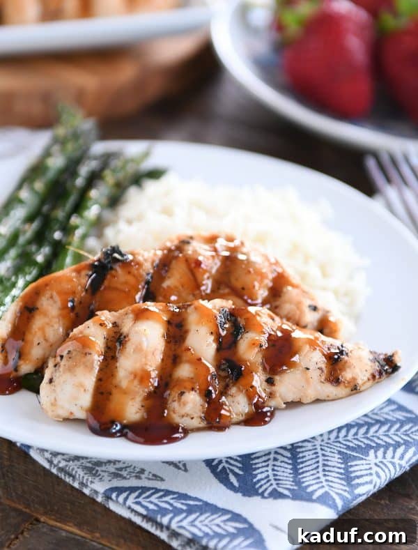 Caramel Coconut Chicken 2 Sticky coconut chicken served on a white plate with fluffy coconut rice and vibrant green asparagus spears. The chicken pieces are glistening with a rich, sticky glaze.