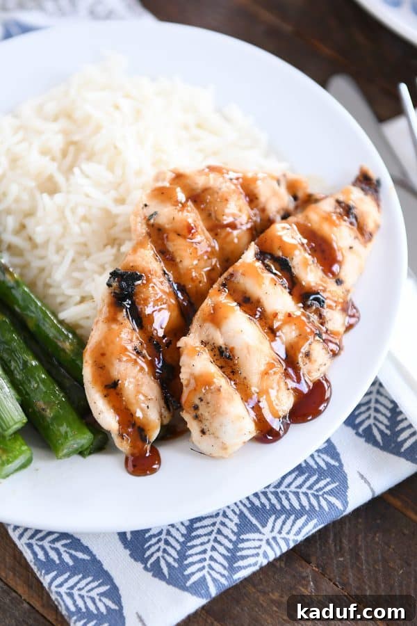 Caramel Coconut Chicken 11 A perfectly plated serving of sticky coconut chicken, accompanied by fragrant coconut rice and tender green asparagus, showcasing the dish's visual appeal and rich glaze.