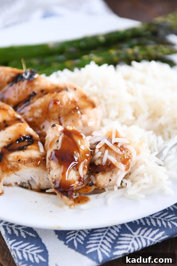 Caramel Coconut Chicken 3 A serving of sticky coconut chicken with a few bites already taken, revealing the tender meat inside, accompanied by a spoonful of aromatic coconut rice.