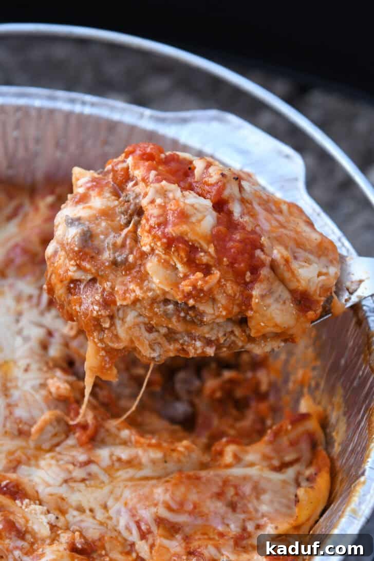 Hearty Dutch Oven Lasagna 2 Spoonful of Dutch oven lasagna, rich with melted cheese and meat sauce.