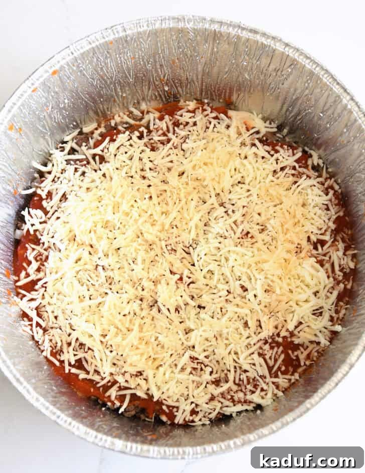 Hearty Dutch Oven Lasagna 10 Top down view of shredded cheese layered in Dutch oven liner.