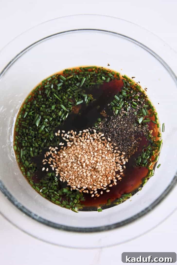 Simple Korean Beef Bulgogi 3 Top down view of glass bowl with soy sauce, sesame seeds, pepper and green onions.