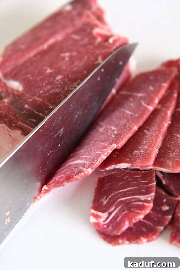 Simple Korean Beef Bulgogi 4 Pieces of thinly sliced beef, knife and white cutting board.