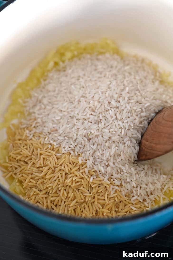 Ultimate Rice Pilaf 3 Long grain white rice and orzo pasta being toasted with butter and onions in a cast iron pot.