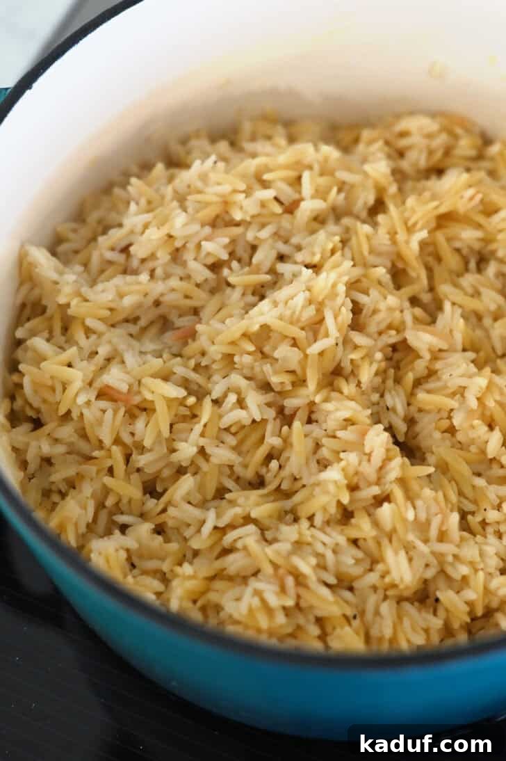 Ultimate Rice Pilaf 6 Fluffy, perfectly cooked rice pilaf glistening in a cast iron pot after resting.