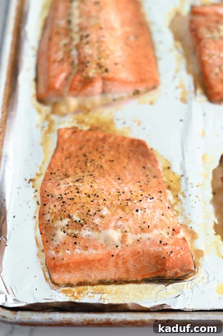 Ultimate Baked Salmon 6 Baked salmon filets on foil-lined baking sheet.